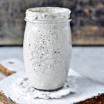 clear glass jar on white wooden table explaining What can I do with sourdough discard?